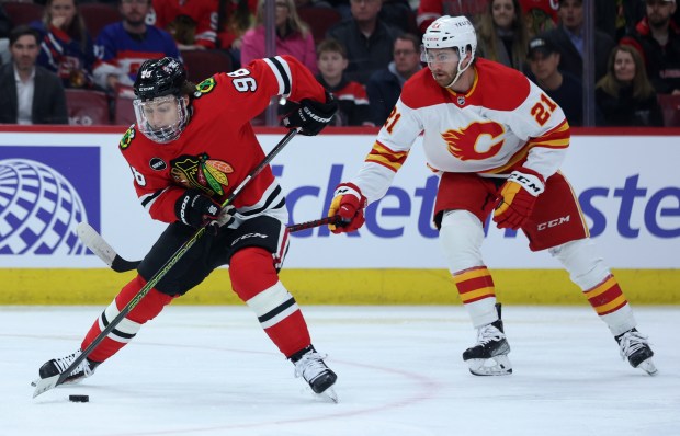 Chicago Blackhawks center Connor Bedard (98) makes a move in front of Calgary Flames center Kevin Rooney (21) in the first period of a game at the United Center in Chicago on March 26, 2024. (Chris Sweda/Chicago Tribune)