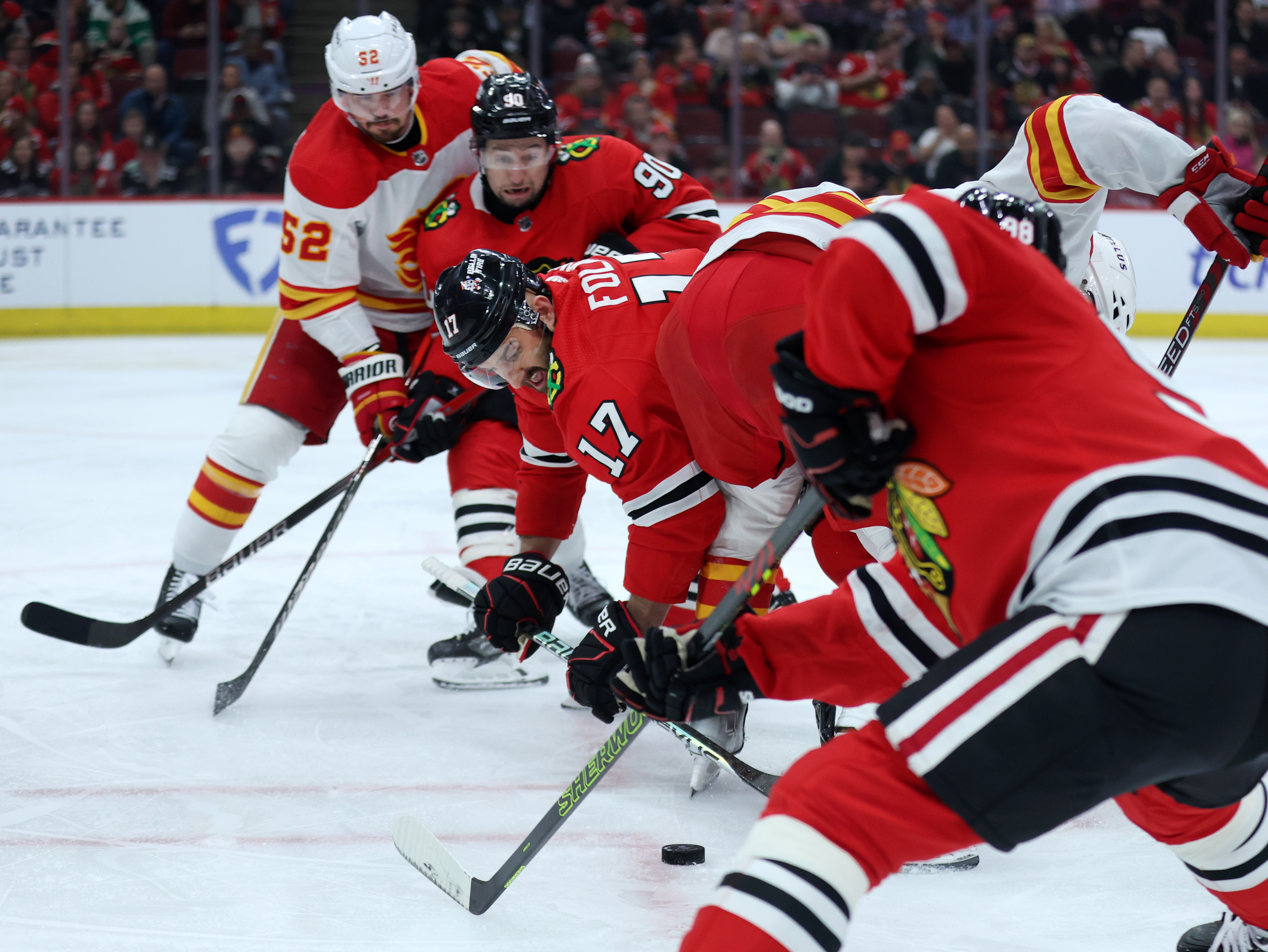 Chicago Blackhawks left wing Nick Foligno (17) tries to take control of the puck in the first period of a game against the Calgary Flames at the United Center in Chicago on March 26, 2024. (Chris Sweda/Chicago Tribune)