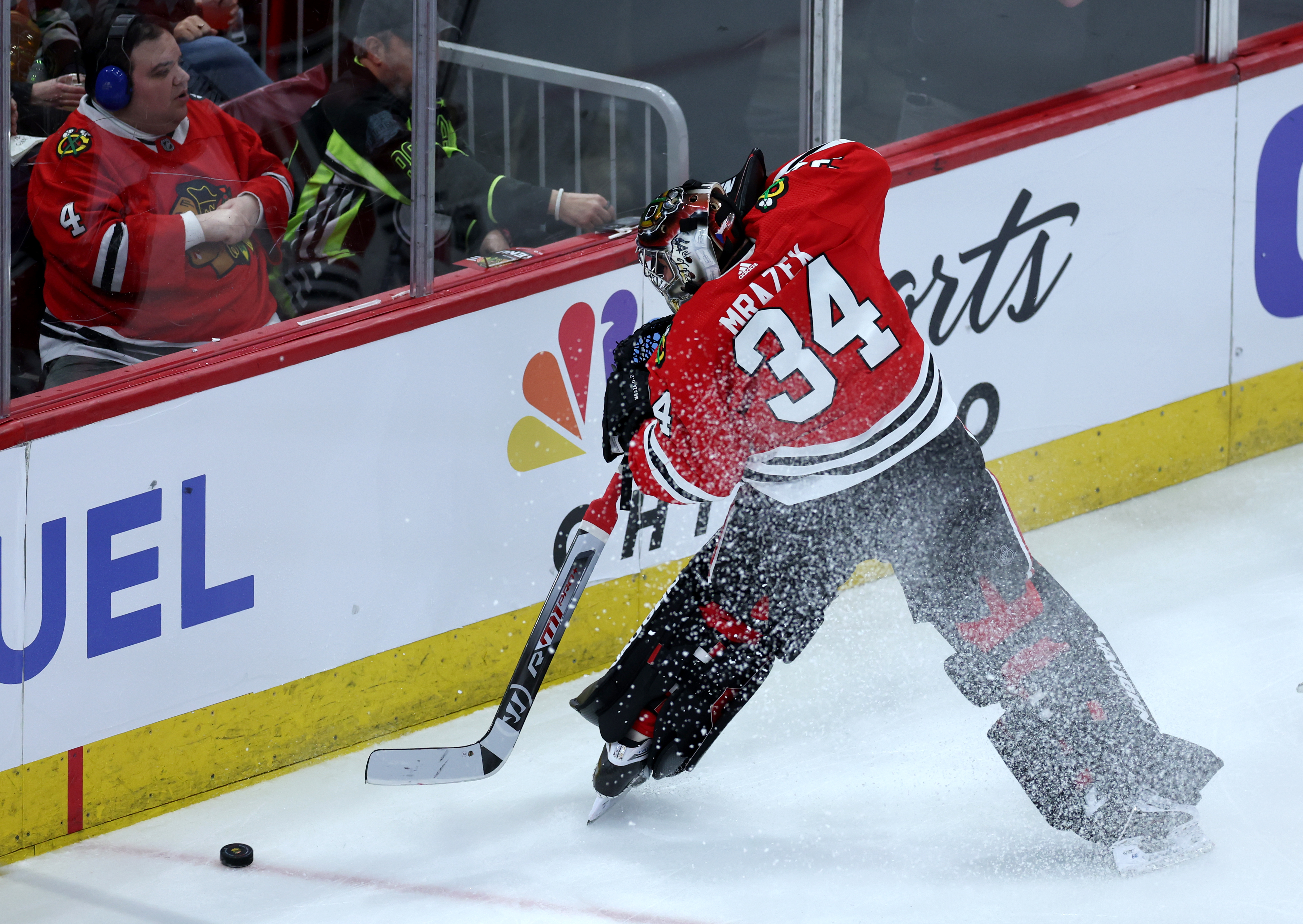 Chicago Blackhawks goaltender Petr Mrazek (34) clears the puck from along the boards in the second period of a game against the Calgary Flames at the United Center in Chicago on March 26, 2024. (Chris Sweda/Chicago Tribune)