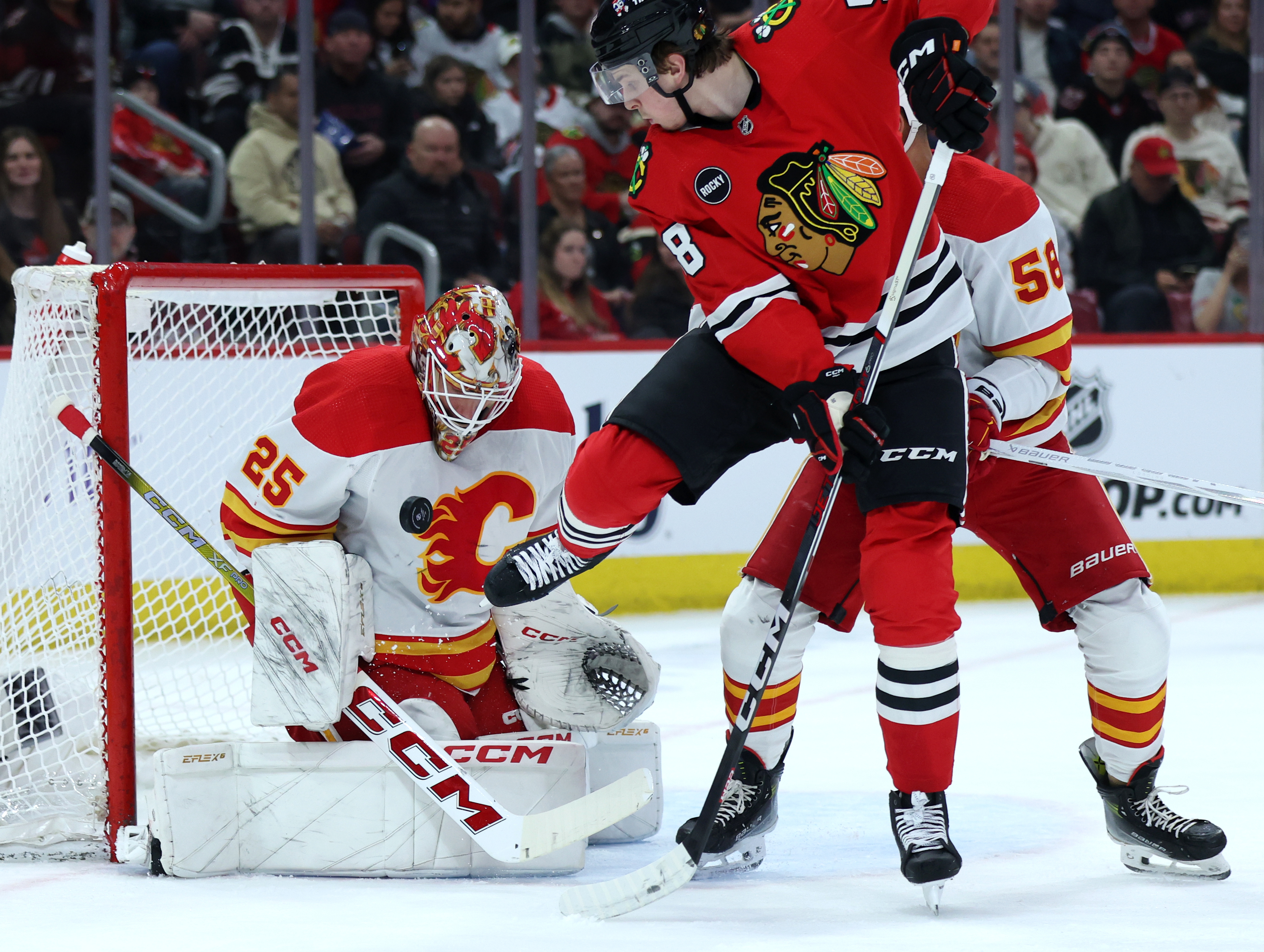 Calgary Flames goaltender Jacob Markstrom (25) blocks a shot as Chicago Blackhawks right wing MacKenzie Entwistle (58) tires to score in the first period of a game at the United Center in Chicago on March 26, 2024. (Chris Sweda/Chicago Tribune)