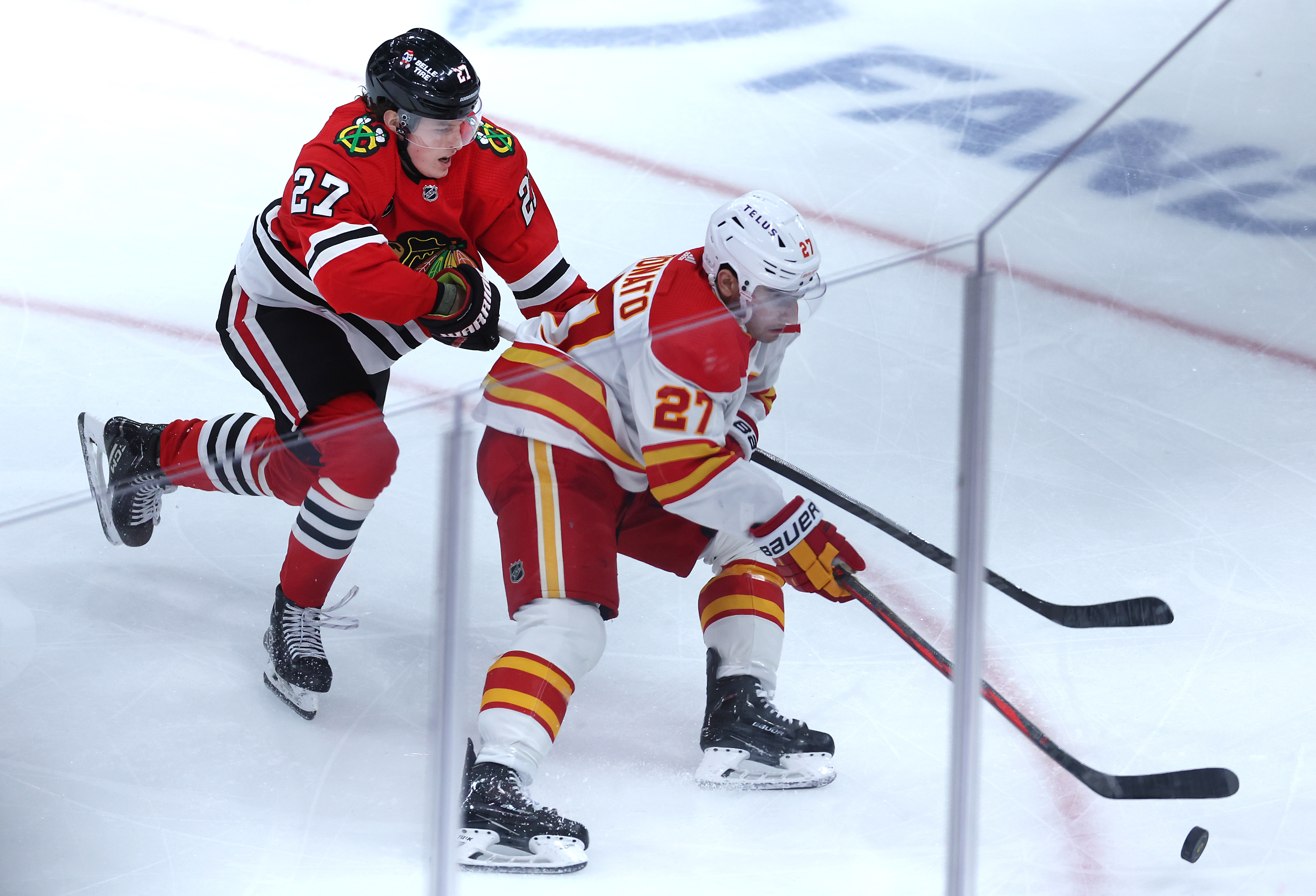 Chicago Blackhawks left wing Lukas Reichel (left) and Calgary Flames right wing Matt Coronato (right) battle in the third period of a game at the United Center in Chicago on March 26, 2024. (Chris Sweda/Chicago Tribune)