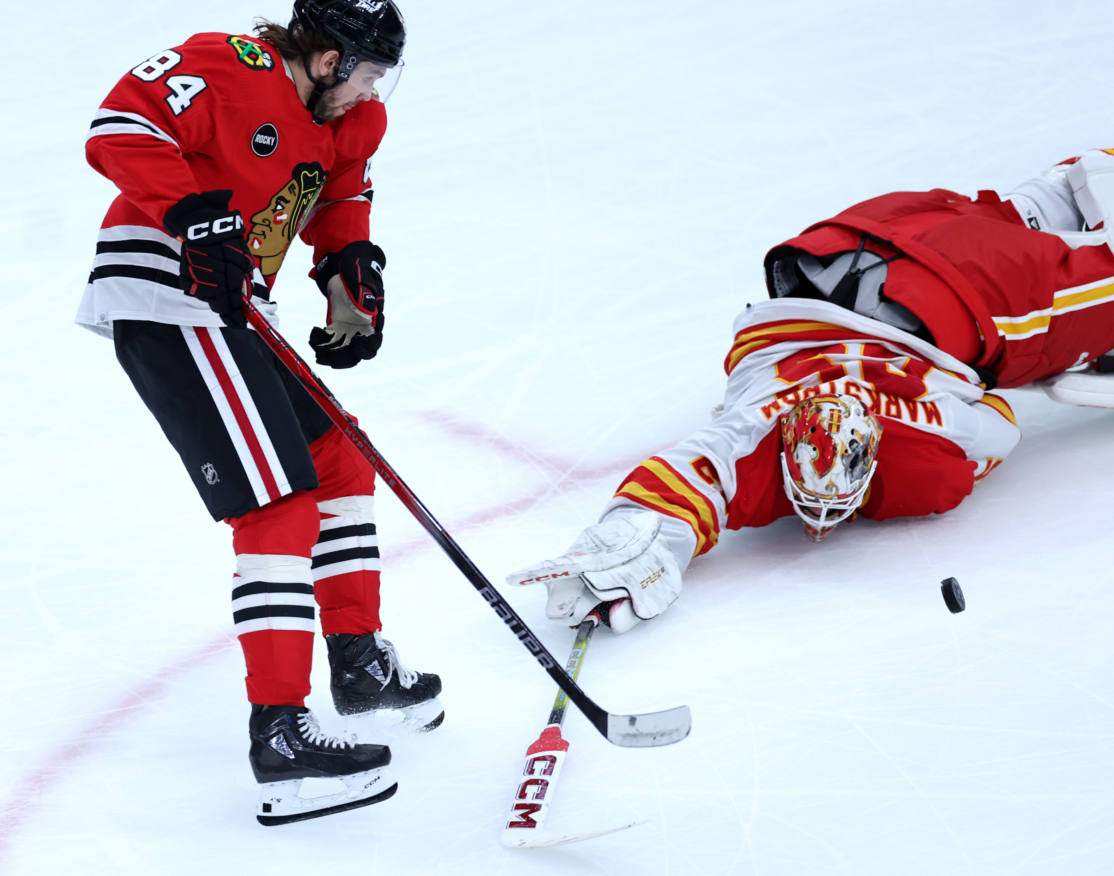 Chicago Blackhawks left wing Landon Slaggert (84) is unable to score after getting the puck past diving Calgary Flames goaltender Jacob Markstrom (25) in the second period of a game at the United Center in Chicago on March 26, 2024. (Chris Sweda/Chicago Tribune)