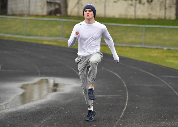 Aurora Central Catholic's Patrick Hilby warms up during a track team practice, Tuesday, March 26, 2024, in Aurora.(Jon Cunningham/for The Beacon-News)
