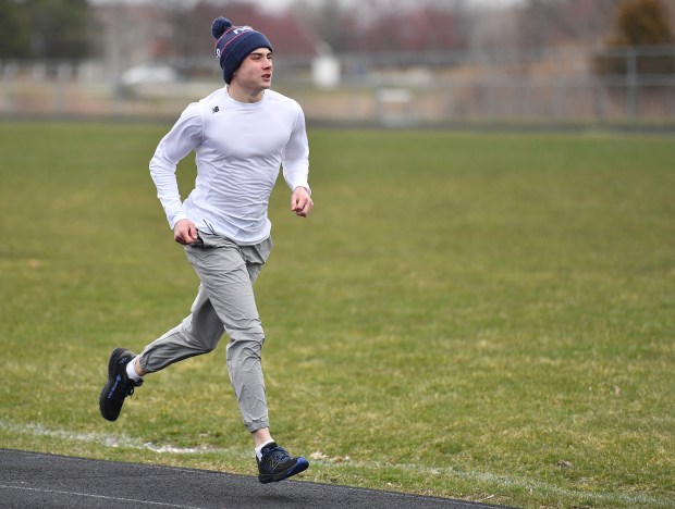 Aurora Central Catholic's Patrick Hilby warms up during a track team practice, Tuesday, March 26, 2024, in Aurora.(Jon Cunningham/for The Beacon-News)