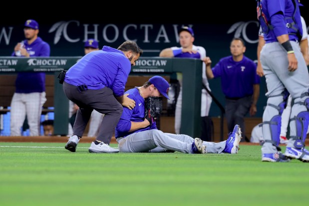 Chicago Cubs starting pitcher Justin Steele lies on the ground after injuring his left leg during the fifth inning of the team's baseball game against the Texas Rangers, Thursday, March 28, 2024 in Arlington, Texas. (AP Photo/Gareth Patterson)