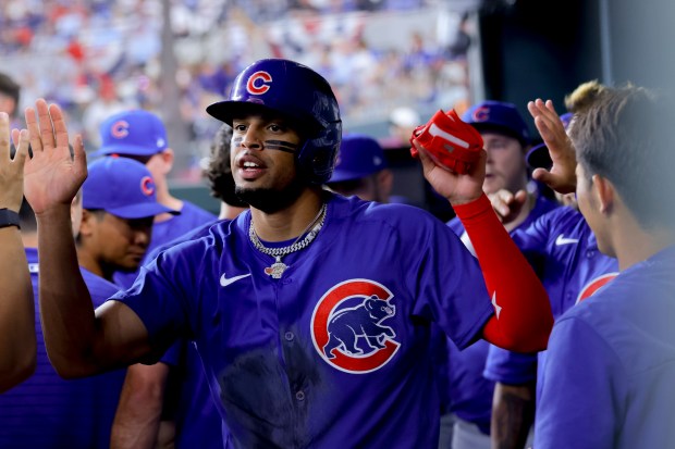 Cubs designated hitter Christopher Morel is congratulated in the dugout after scoring in the second inning against the Rangers on March 28, 2024, in Arlington, Texas. Morel had tripled to lead off the inning, and the run was the Cubs' first of the season. (Gareth Patterson/AP)