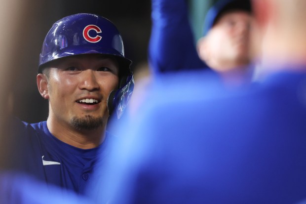 Cubs right fielder Seiya Suzuki is congratulated by teammates in the dugout after scoring during the sixth inning against the Texas Rangers on March 28, 2024, in Arlington, Texas. (Stacy Revere/Getty)