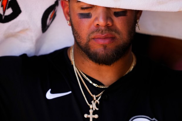 White Sox third baseman Yoan Moncada wraps a towel around his head in the dugout during a spring training game against the Padres on Saturday, March 9, 2024, in Peoria, Ariz. (AP Photo/Lindsey Wasson)