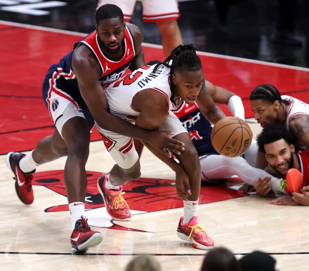Bulls guard Ayo Dosunmu (12) picks up a loose ball in the second half against the Wizards on March 16, 2024, at the United Center. (Chris Sweda/Chicago Tribune)