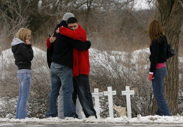 People hug in 2007 at a memorial set up for the five teens killed in a single-vehicle crash in Oswego on Feb. 11, 2007. Matthew Frank, Katherine Merkel, Jessica Mutoni, Tiffany Urso and James McGee died in the crash. Sandra Vasquez, convicted of aggravated drunken driving and reckless homicide in connection with the crash, was released from prison Tuesday.