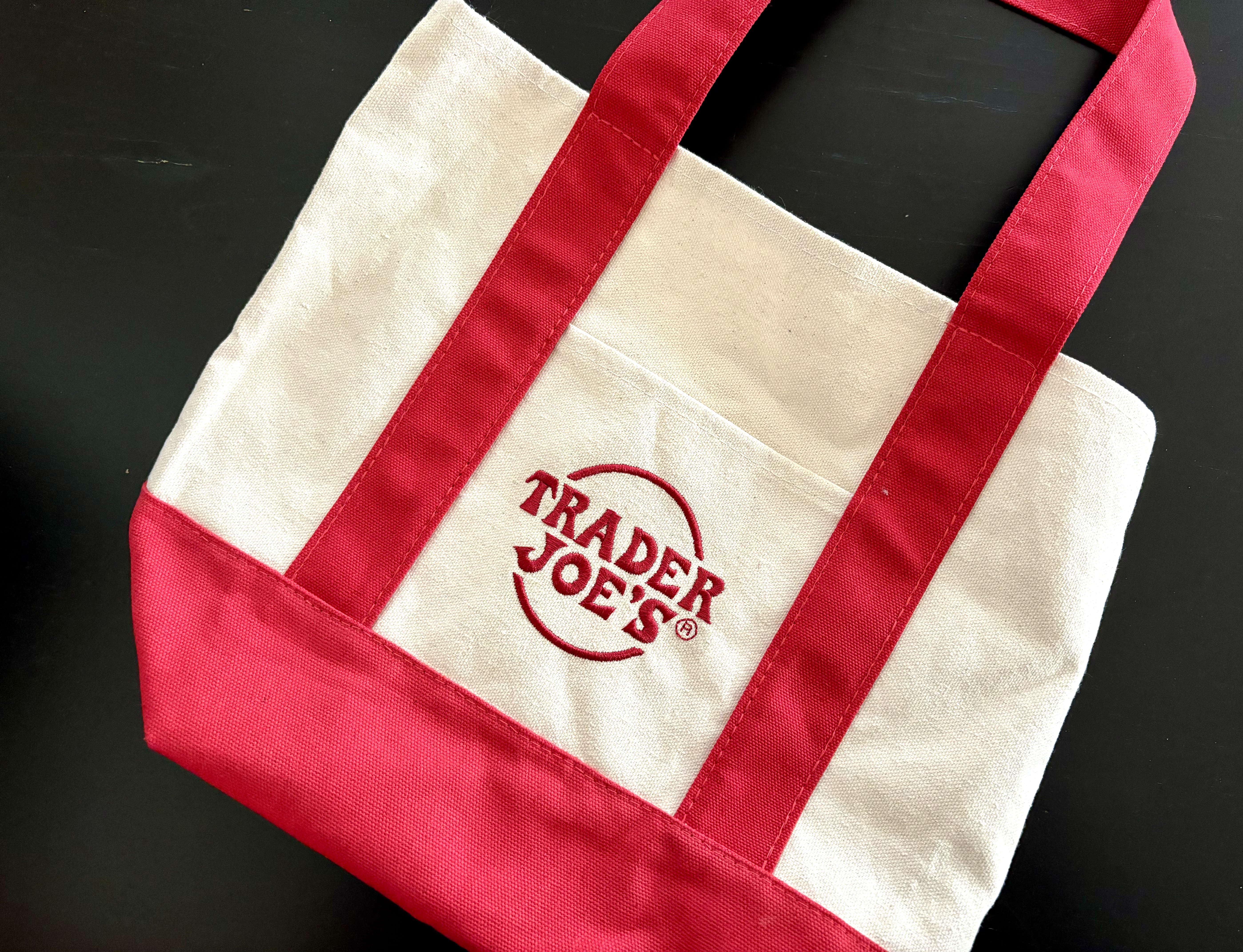 A mini red and white Trader Joe's tote bag.