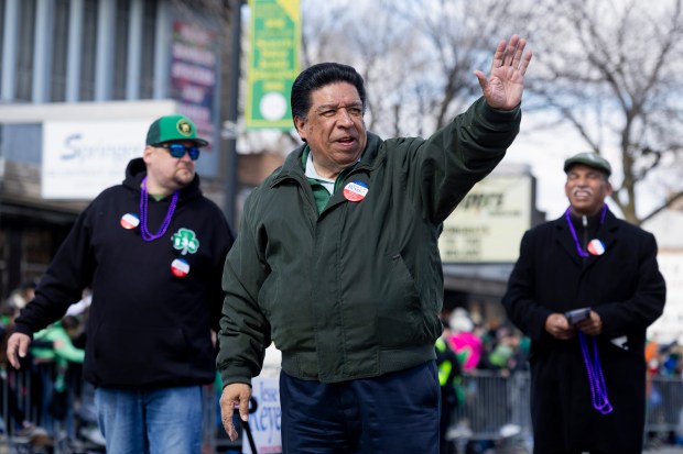 Justice Jesse G. Reyes, candidate for Illinois Supreme Court, waves to the crowd during the 46th South Side Irish St. Patrick's Day Parade on Sunday, March 17, 2024, on Western Ave. in Chicago. (Vincent Alban/Chicago Tribune)