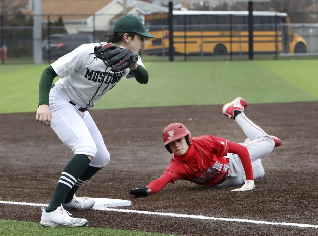 Evergreen Park's Jack Hughes, left, applies the tag to T.F. South's Tyler Earmsmuth at third base during a South Suburban Conference crossover in Evergreen Park on Monday, April 4, 2022.