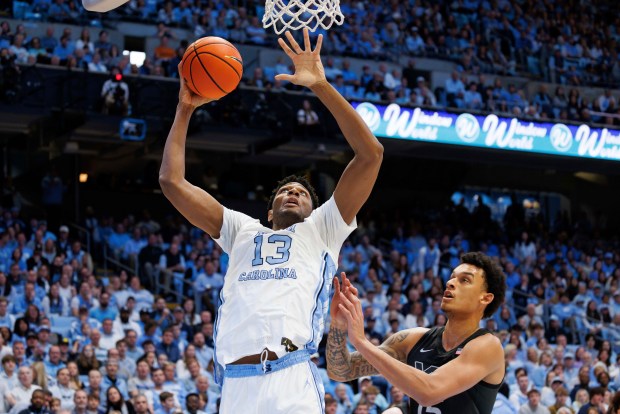 North Carolina's Jalen Washington (13) attempts to shoot ahead of Virginia Tech's Lynn Kidd, right, during the first half of an NCAA college basketball game in Chapel Hill, N.C., Saturday, Feb. 17, 2024. (AP Photo/Ben McKeown)