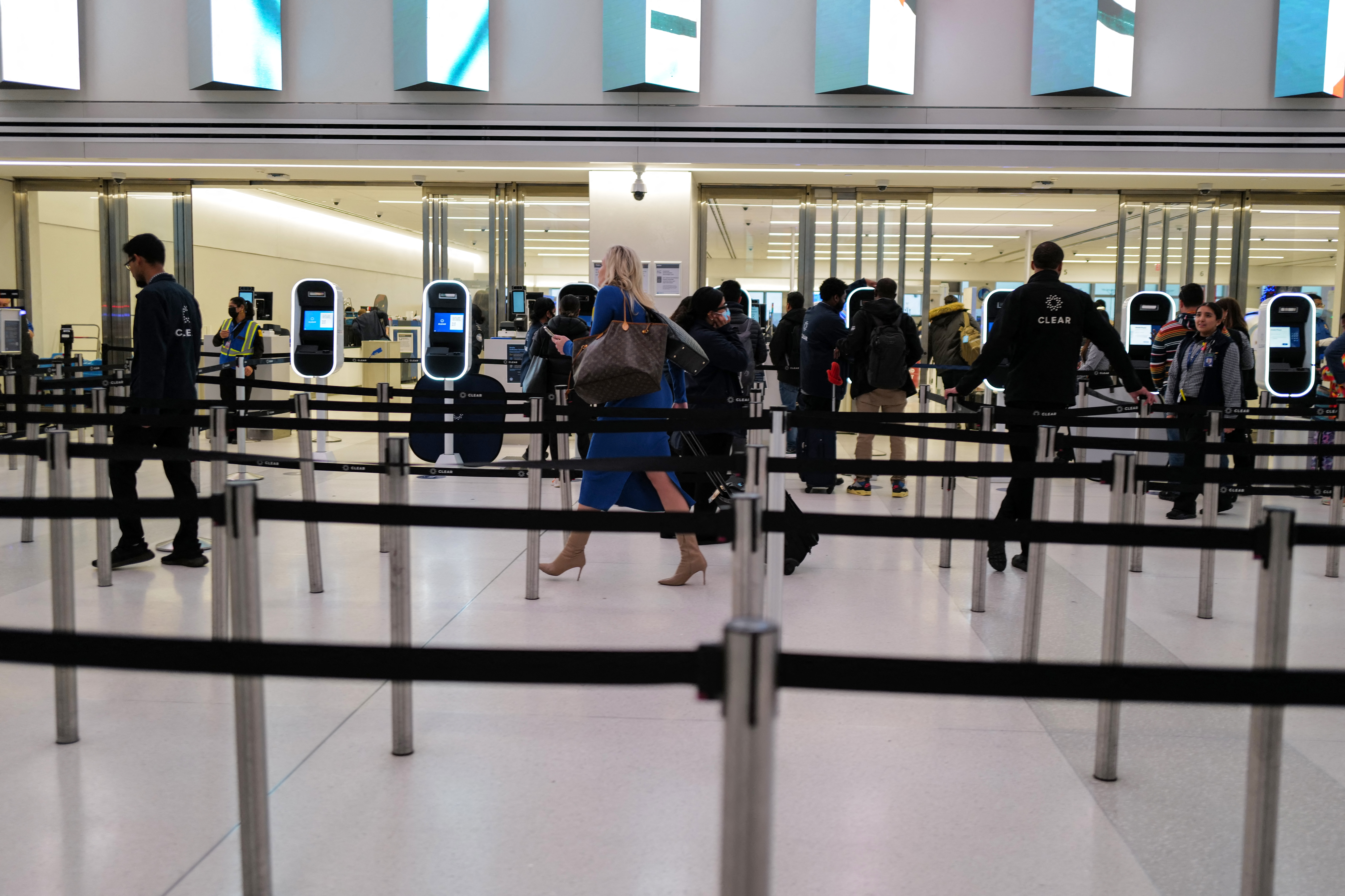 Travelers queue to pass through the security gate in the Terminal C of La Guardia Airport.