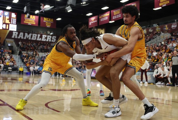 Loyola center Miles Rubin (24) is sandwiched by La Salle guards Anwar Gill, left, and Tunde Vahlberg Fasasi on March 9, 2024, at Gentile Arena. (John J. Kim/Chicago Tribune)