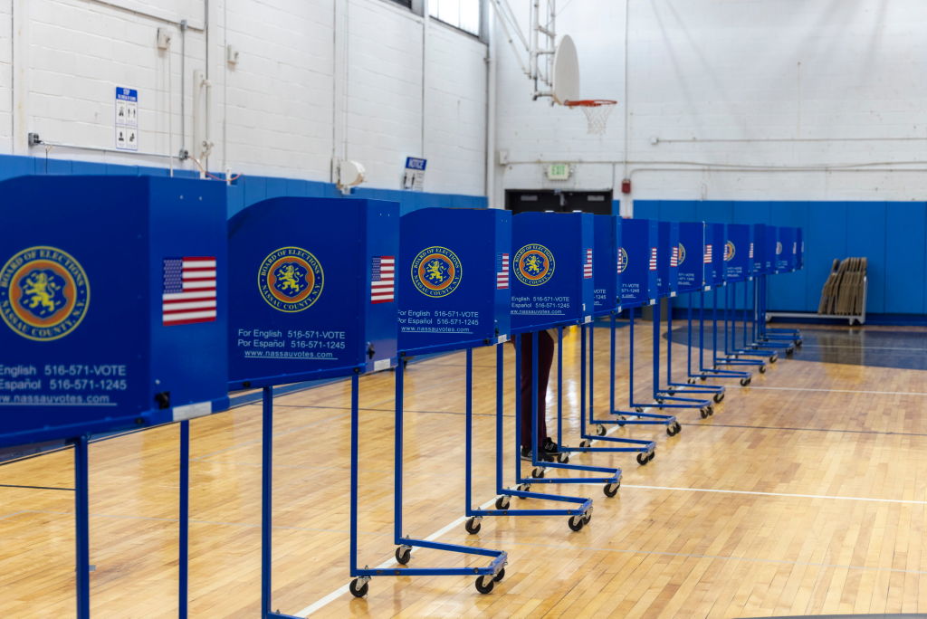A line of blue privacy dividers in a gymnasium on Election Day.