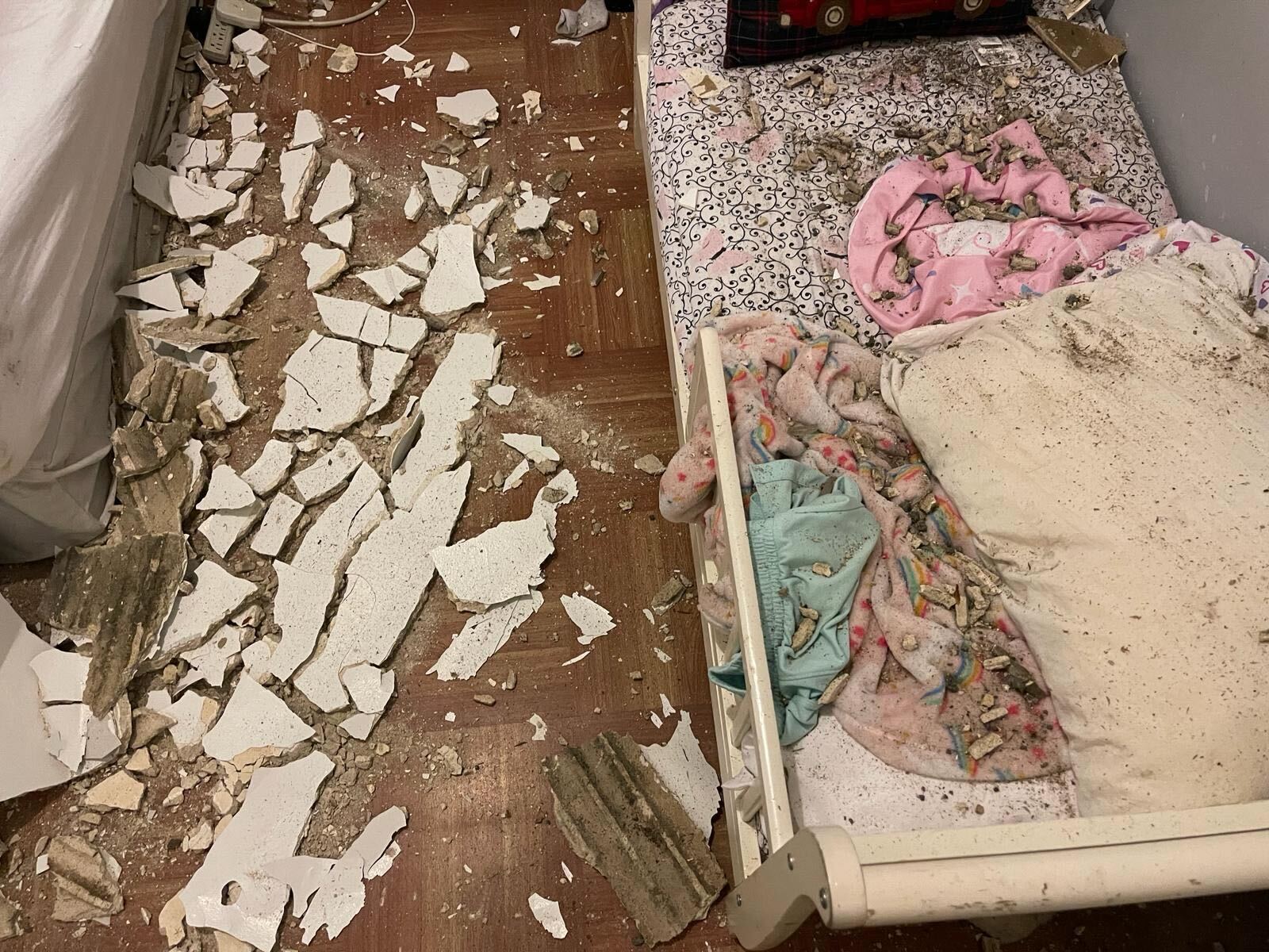Dry wall and other material from a collapsed ceiling fell onto a child's bed.