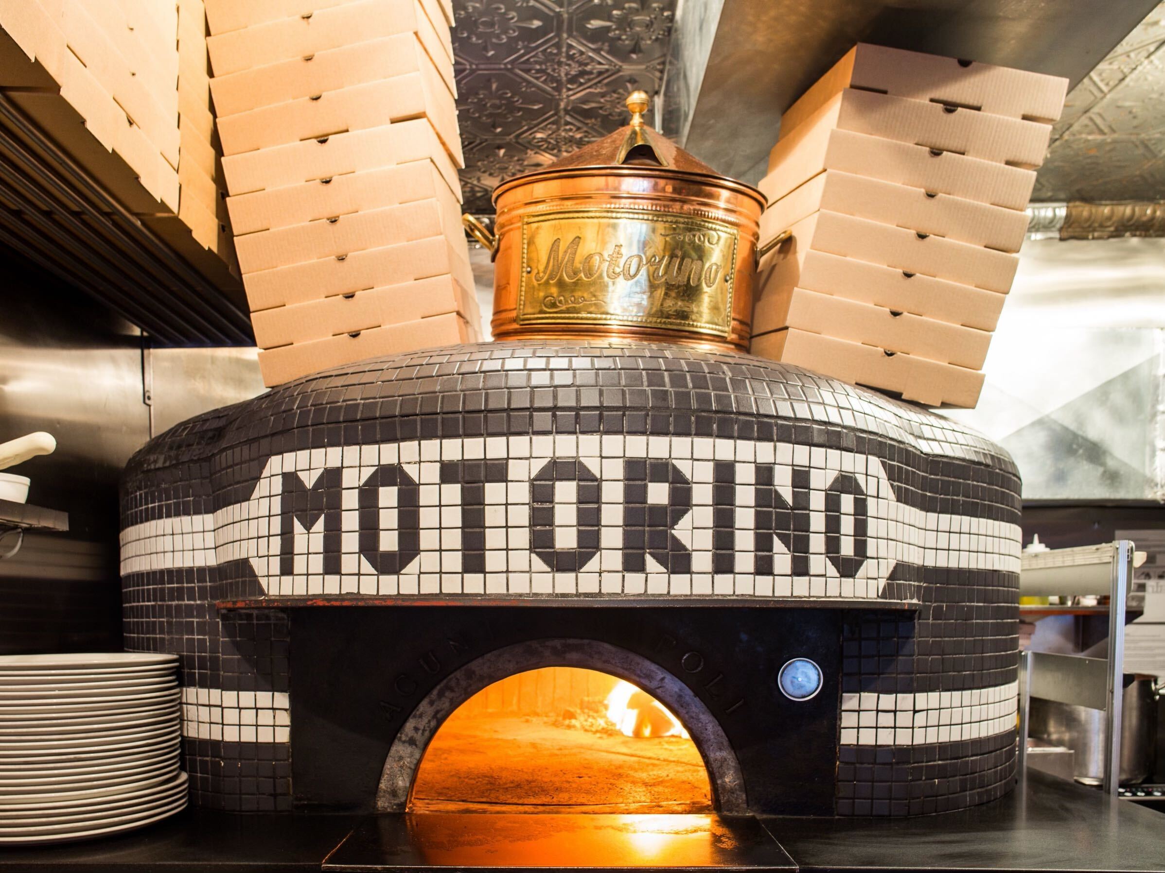A wood-fired oven with "Motorino" written on it.