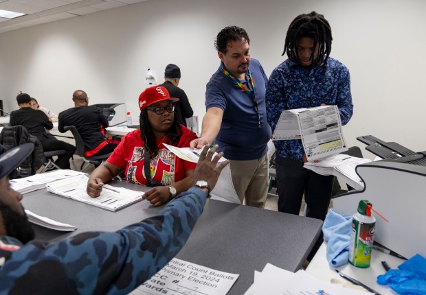 Election judges count mail-in ballots by running them through a scanner, March 25, 2024, at the Chicago Board of Elections. (Brian Cassella/Chicago Tribune)