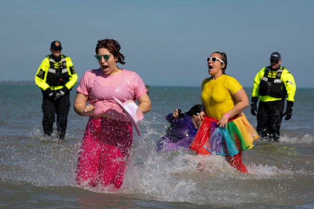 Costumed participants take a dip in Lake Michigan on a warm morning during the 24th Annual Chicago Polar Plunge on Sunday, March 3, 2024, at North Avenue Beach. (Brian Cassella/Chicago Tribune)