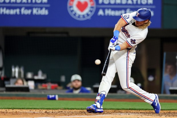 ARLINGTON, TEXAS - MARCH 28: Travis Jankowski #16 of the Texas Rangers hits a home run against the Chicago Cubs during the ninth inning of the Opening Day game at Globe Life Field on March 28, 2024 in Arlington, Texas. (Photo by Stacy Revere/Getty Images)