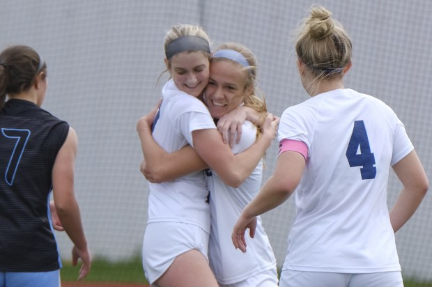 Oswego East's Erika Smiley hugs teammate Anya Gulbrandsen, right, after Gulbrandsen scored the first goal against St. Charles North in a Naperville Invitational game on Saturday, April 23, 2022.