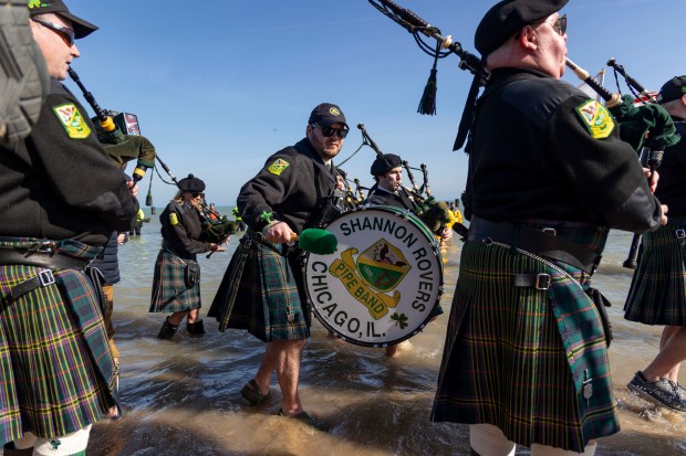 The Shannon Rovers lead the procession as participants take a dip in Lake Michigan on a warm morning during the 24th Annual Chicago Polar Plunge on Sunday, March 3, 2024, at North Avenue Beach. (Brian Cassella/Chicago Tribune)