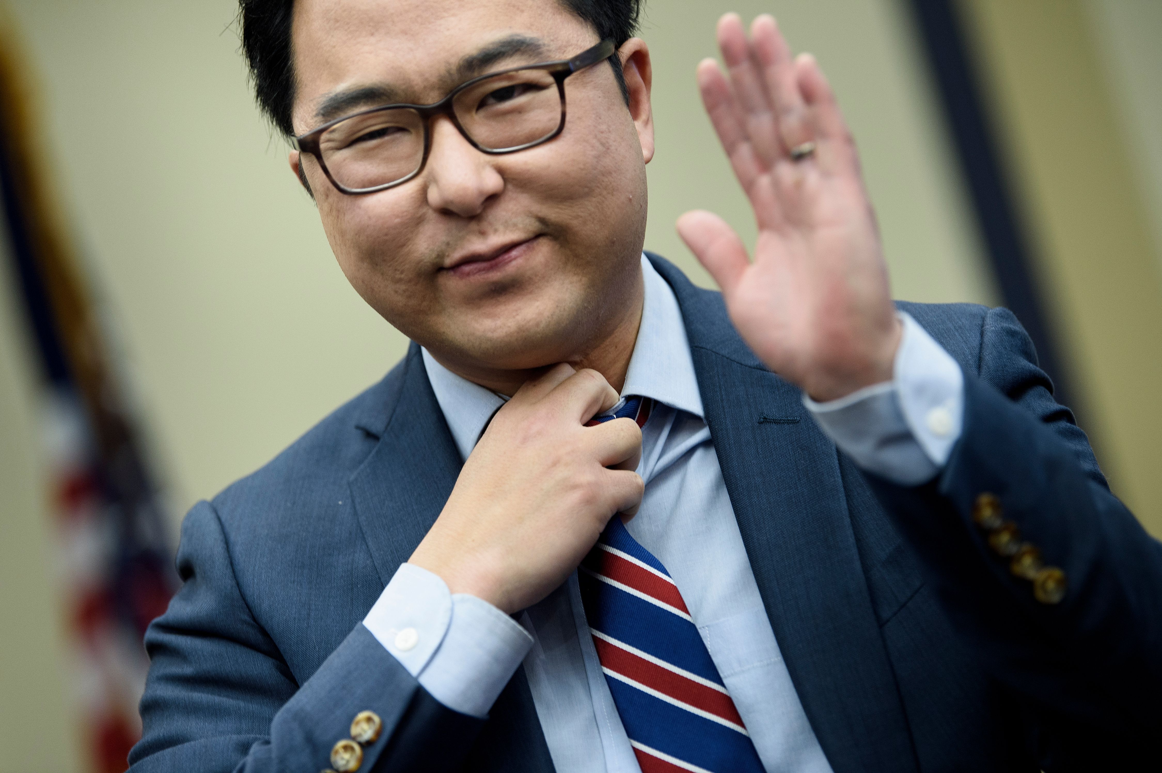 Rep. Andy Kim smiling and holding up his hand.