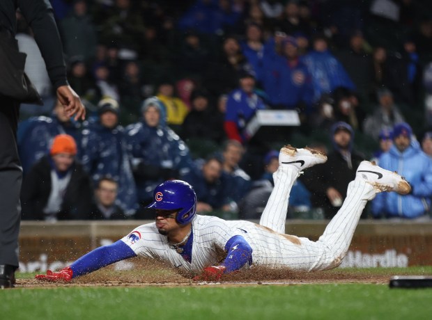 Chicago Cubs third baseman Christopher Morel (5) slides in safely at home plate while scoring on a sacrifice fly in the second inning of a game against the Colorado Rockies at Wrigley Field in Chicago on Wednesday, April 3, 2024. (Chris Sweda/Chicago Tribune)
