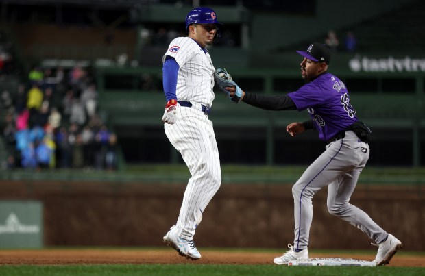Chicago Cubs right fielder Seiya Suzuki (27) is tagged out by Colorado Rockies second baseman Alan Trejo after Suzuki was caught between first and second following a 2-run single in the second inning of a game at Wrigley Field in Chicago on Wednesday, April 3, 2024. (Chris Sweda/Chicago Tribune)