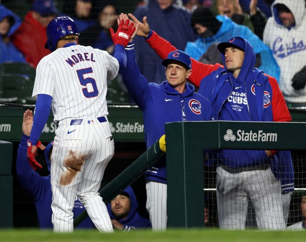Chicago Cubs third baseman Christopher Morel (5) is congratulated by manager Craig Counsell after Morel scored on a sacrifice fly in the second inning of a game against the Colorado Rockies at Wrigley Field in Chicago on Wednesday, April 3, 2024. (Chris Sweda/Chicago Tribune)