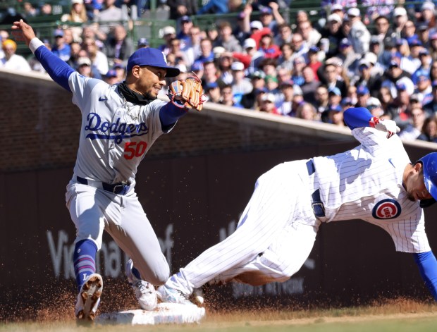 Cubs right fielder Seiya Suzuki (27) slides into second base safely before the tag by Dodgers second baseman Mookie Betts (50) in the first inning on April 6, 2024, at Wrigley Field. (John J. Kim/Chicago Tribune)