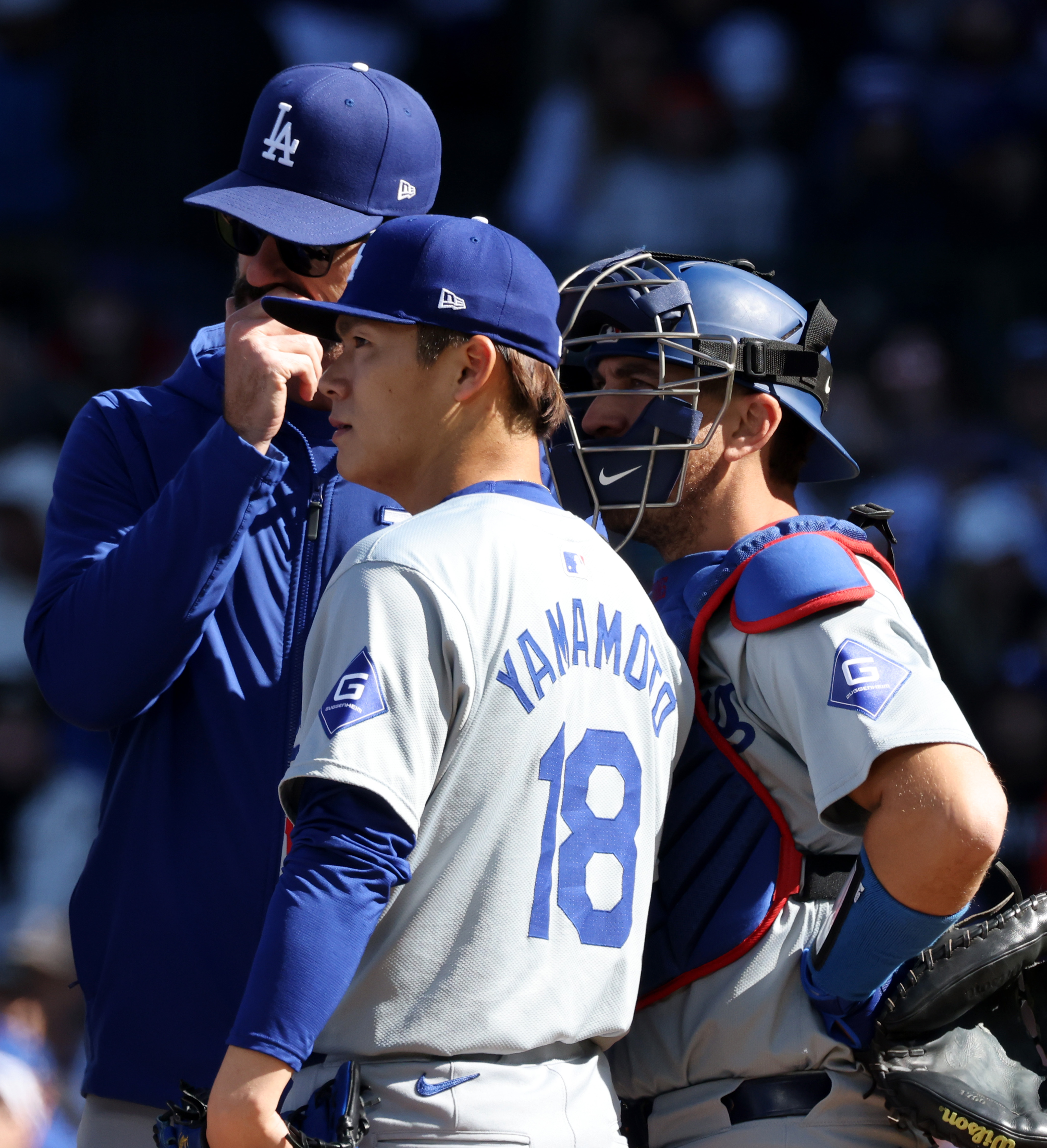 Dodgers pitcher Yoshinobu Yamamoto (18) takes a meeting on the mound against the Cubs in the first inning on April 6, 2024, at Wrigley Field. (John J. Kim/Chicago Tribune)