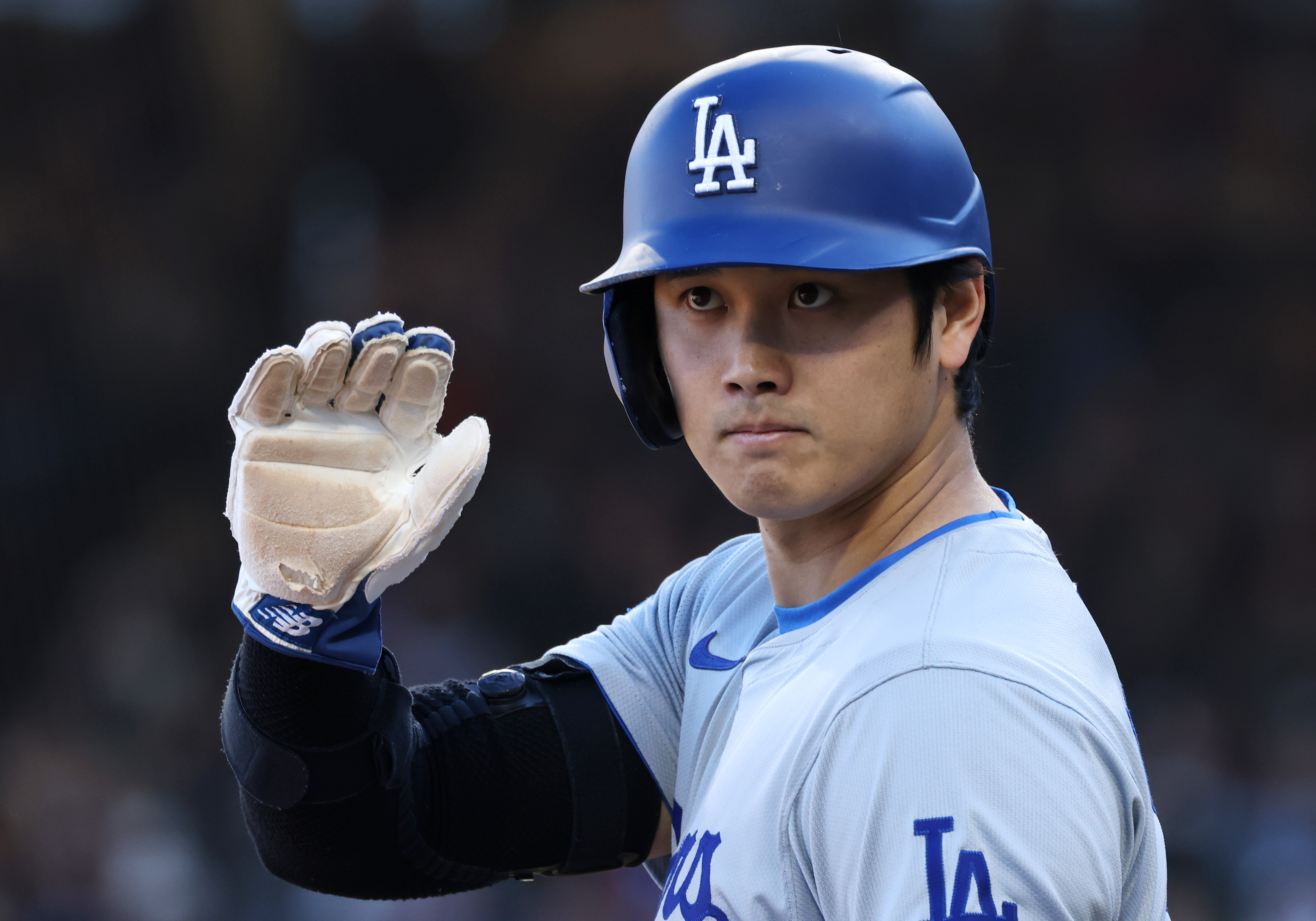 Dodgers designated hitter Shohei Ohtani waves to the third-base umpire while standing at third base in the fifth inning against the Cubs on April 6, 2024, at Wrigley Field. (John J. Kim/Chicago Tribune)