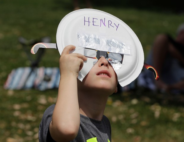 Henry Boritt watches the solar eclipse during a watch party at Holiday Park, Monday, Aug. 21, 2017, in Indianapolis. (AP Photo/Darron Cummings)