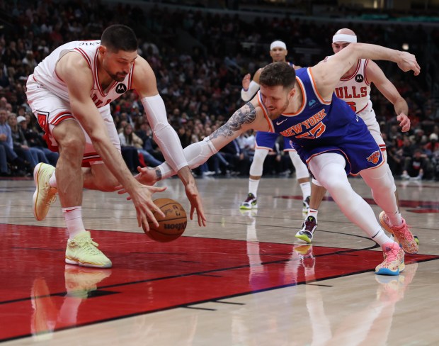 Chicago Bulls center Nikola Vucevic (left) and New York Knicks center Isaiah Hartenstein (55) battle for a loose ball in the second half of a game at the United Center in Chicago on April 9, 2024. (Chris Sweda/Chicago Tribune)