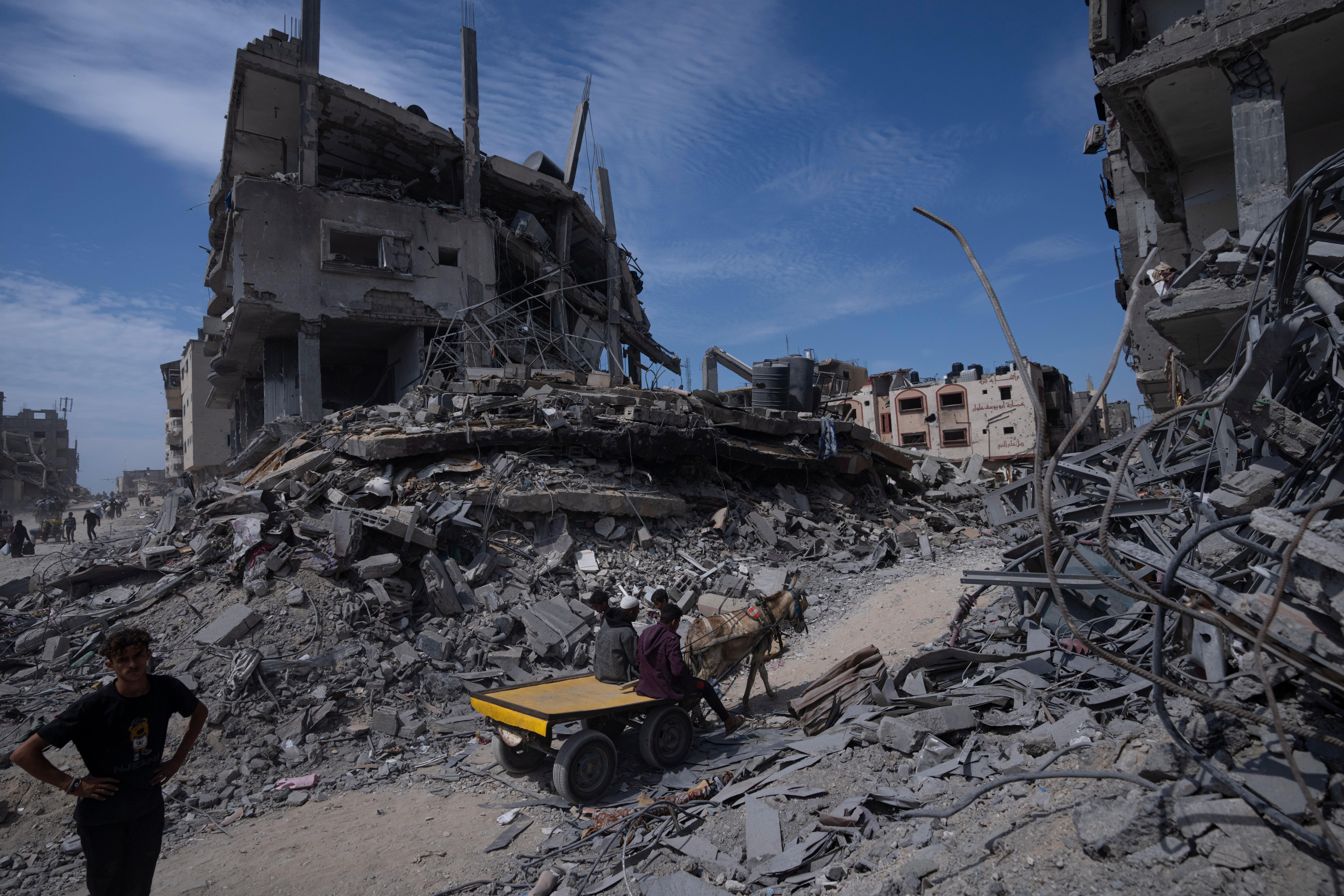 Palestinians walk through the destruction in the wake of an Israeli air and ground offensive in Khan Younis, southern Gaza Strip, Monday, April 8, 2024. Israel says it has withdrawn its last ground troops from the city, ending a four-month operation. (AP Photo/Fatima Shbair)