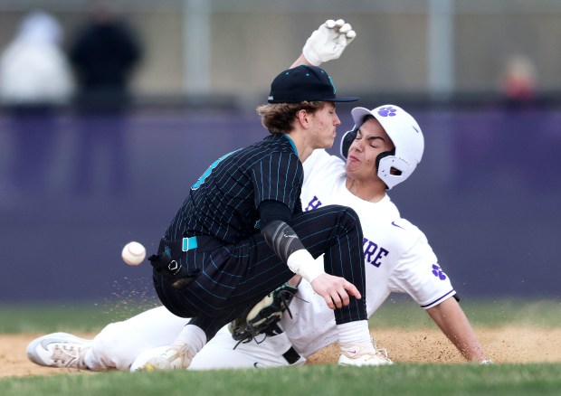 Hampshire's Jaryd Vence (5) slides safely into second as Woodstock North's Trevor Mark (3) misses the throw during a non-conference game on Thursday, April, 11, 2024 in Hampshire. Hampshire won, 15-0 in four innings.H. Rick Bamman / For the Beacon News