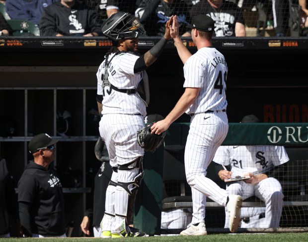 White Sox catcher Martín Maldonado (15) gives pitcher Jordan Leasure (49) a high-five after a 1-2-3 eighth inning against the Reds at Guaranteed Rate Field on April 13, 2024, in Chicago. (John J. Kim/Chicago Tribune)