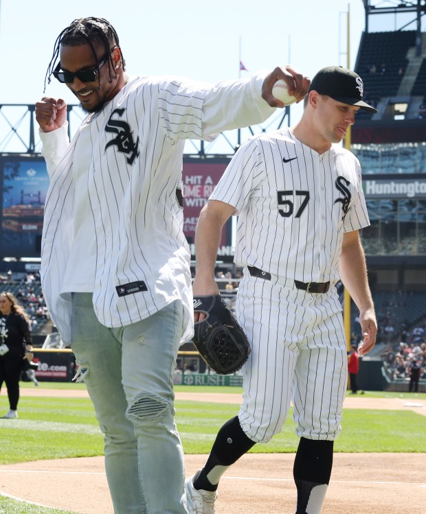 New Chicago Bears safety Jonathan Owens, left, gestures after throwing out a ceremonial first pitch to White Sox pitcher Tanner Banks before a game between the White Sox and Reds at Guaranteed Rate Field on April 13, 2024, in Chicago. (John J. Kim/Chicago Tribune)