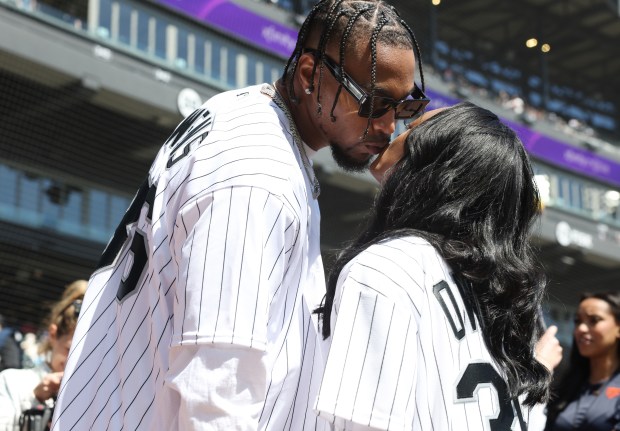 New Chicago Bears safety Jonathan Owens and gymnast Simone Biles kiss before Owens throws out a ceremonial first pitch before a game between the White Sox and Reds at Guaranteed Rate Field on April 13, 2024, in Chicago. (John J. Kim/Chicago Tribune)