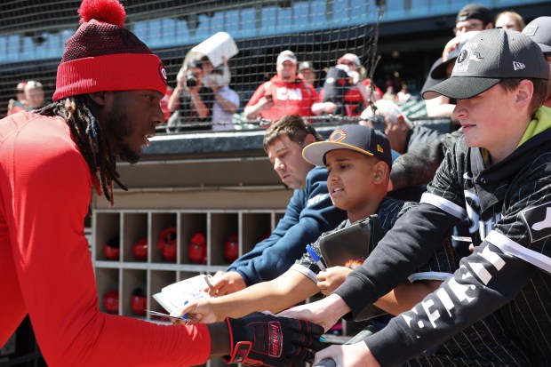 Reds shortstop Elly De La Cruz signs autographs before a game against the Chicago White Sox at Guaranteed Rate Field on April 13, 2024, in Chicago. (John J. Kim/Chicago Tribune)