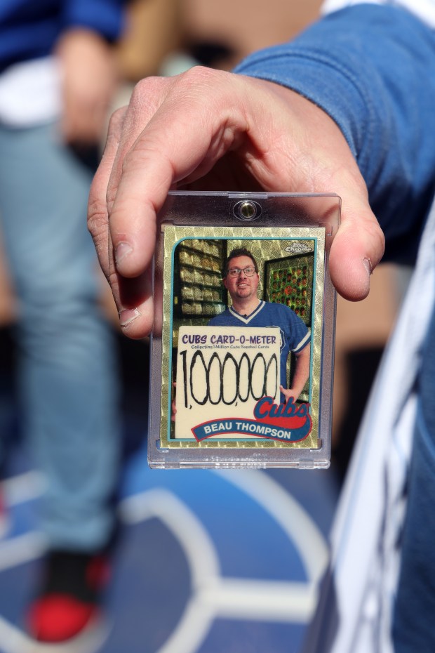 Cubs fan Beau Thompson displays a commemorative card given to him by the team before a game against the Dodgers on April 5, 2024, at Wrigley Field. (Terrence Antonio James/Chicago Tribune)