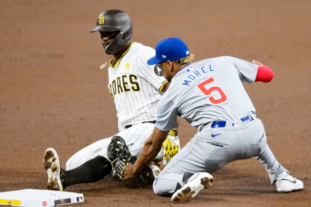 San Diego Padres' Xander Bogaerts, left, is tagged out by Chicago Cubs third baseman Christopher Morel (5) as he tries to steal third base during the first inning of a baseball game, Tuesday, April 9, 2024, in San Diego. (AP Photo/Denis Poroy)