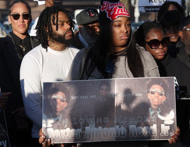 Porscha Banks, center right, sister of Dexter Reed, holds a sign showing her brother at a rally at the Chicago Police Harrison District (11th) station on April 9, 2024, after the Civilian Office of Police Accountability released body camera video of the fatal shooting of Reed, 26, who was killed March 21 in an "exchange of gunfire" with police officers. (Terrence Antonio James/Chicago Tribune)