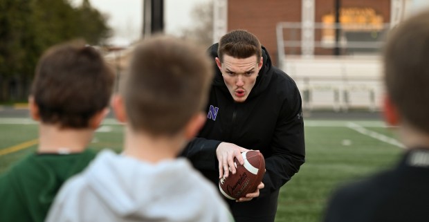 Richie Hagarty, defensive end for the Northwestern University football team, and from New Palestine, Indiana works with young athletes at a GBN Jr. Spartan Football clinic on William Lutz Stadium at Glenbrook North High School on April 7, 2024. (Karie Angell Luc/Pioneer Press)