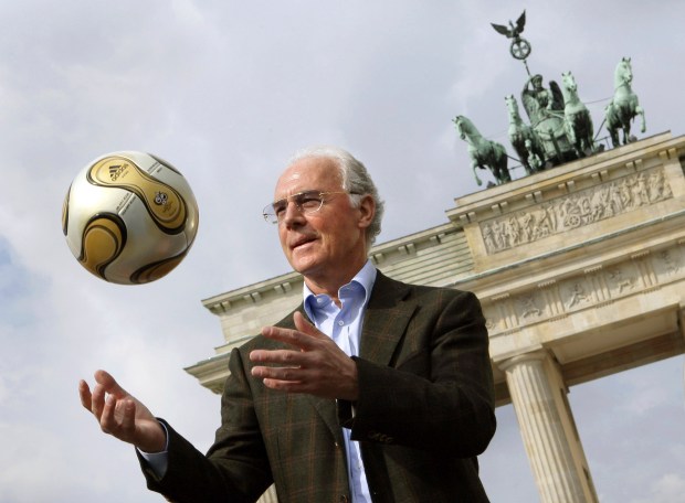 Franz Beckenbauer, president of the 2006 World Cup Organizing Committee, presents the golden soccer ball for the World Cup final in front of the Brandenburg Gate on April 18, 2006.