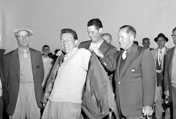 Jack Burke Jr. is helped by Cary Middlecoff as he puts on the green jacket after winning the Masters on April 8, 1956, in Augusta, Ga.