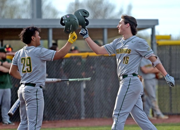 Waubonsie Valley's Hiroshy Wong taps helmets with Ben Ford at the plate as Ford celebrates his home run. Waubonsie Valley defeated Metea Valley in baseball, 7-3, Tuesday, April 16, 2024, in Aurora, Illinois. (Jon Langham/for the Beacon-News)